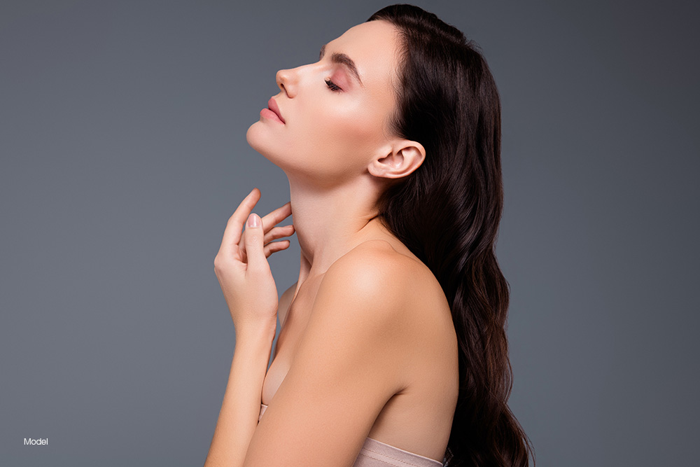 Profile of a young woman touching her neck