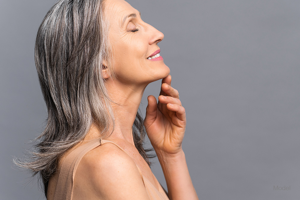 Profile of a mature woman touching her neck